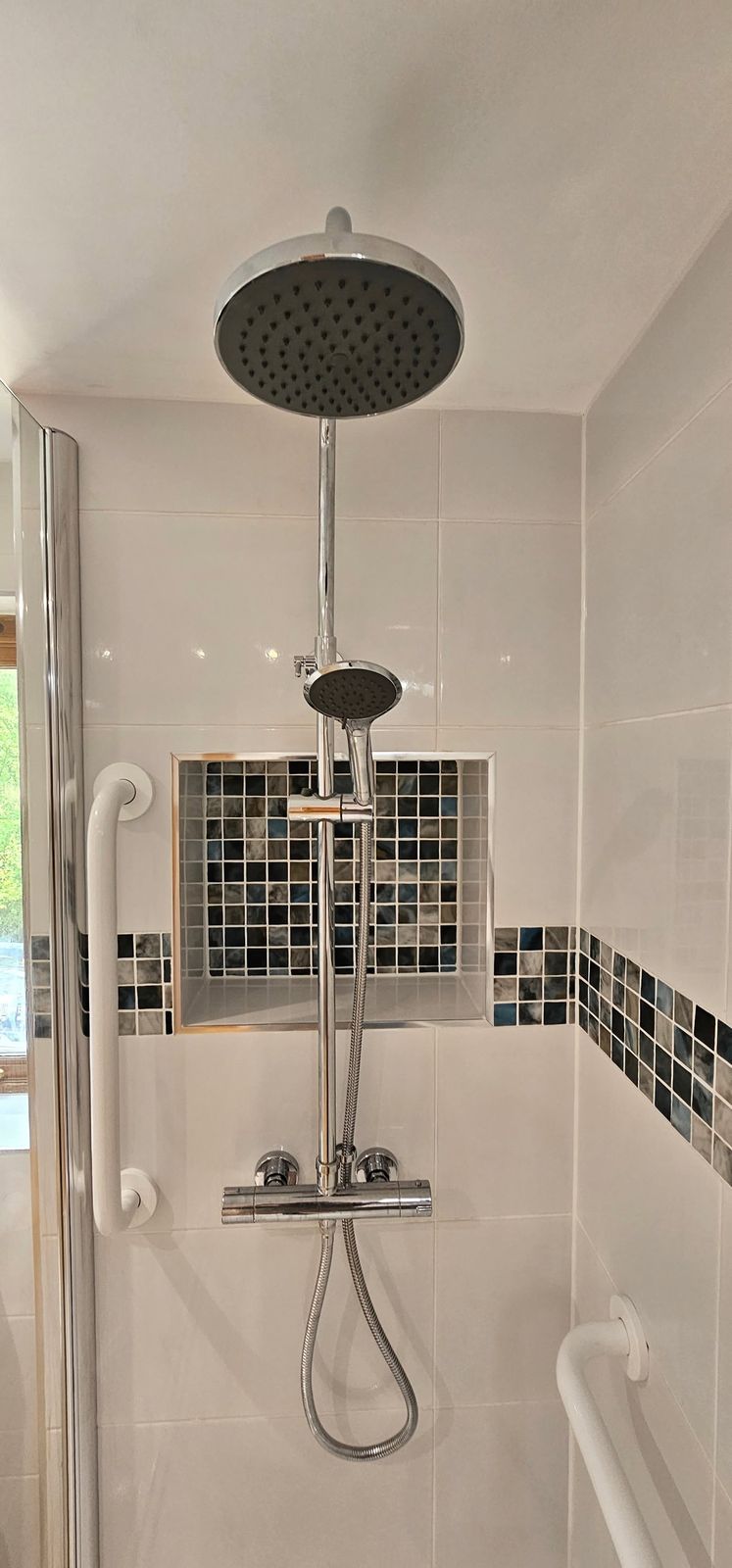 Rainfall shower head and thermostatic bar with a mosaic tile border and grab rail
