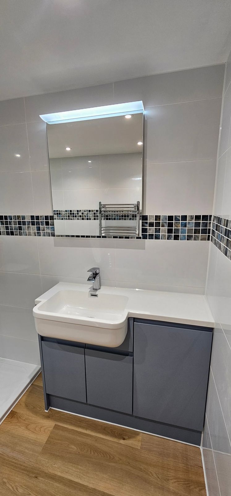 Vanity unit and illuminated mirror cabinet in the finished bathroom
