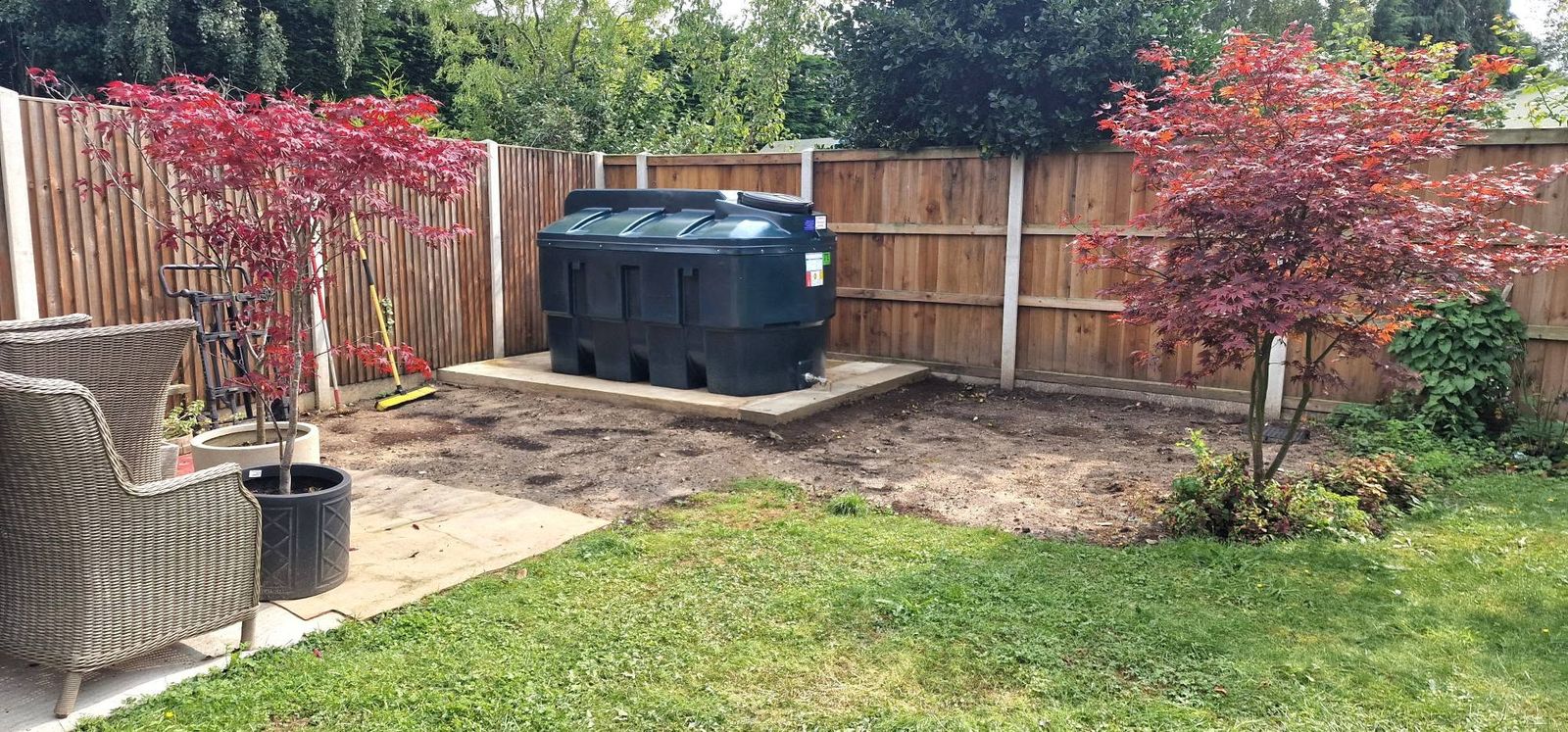 New green oil tank on a base in a garden