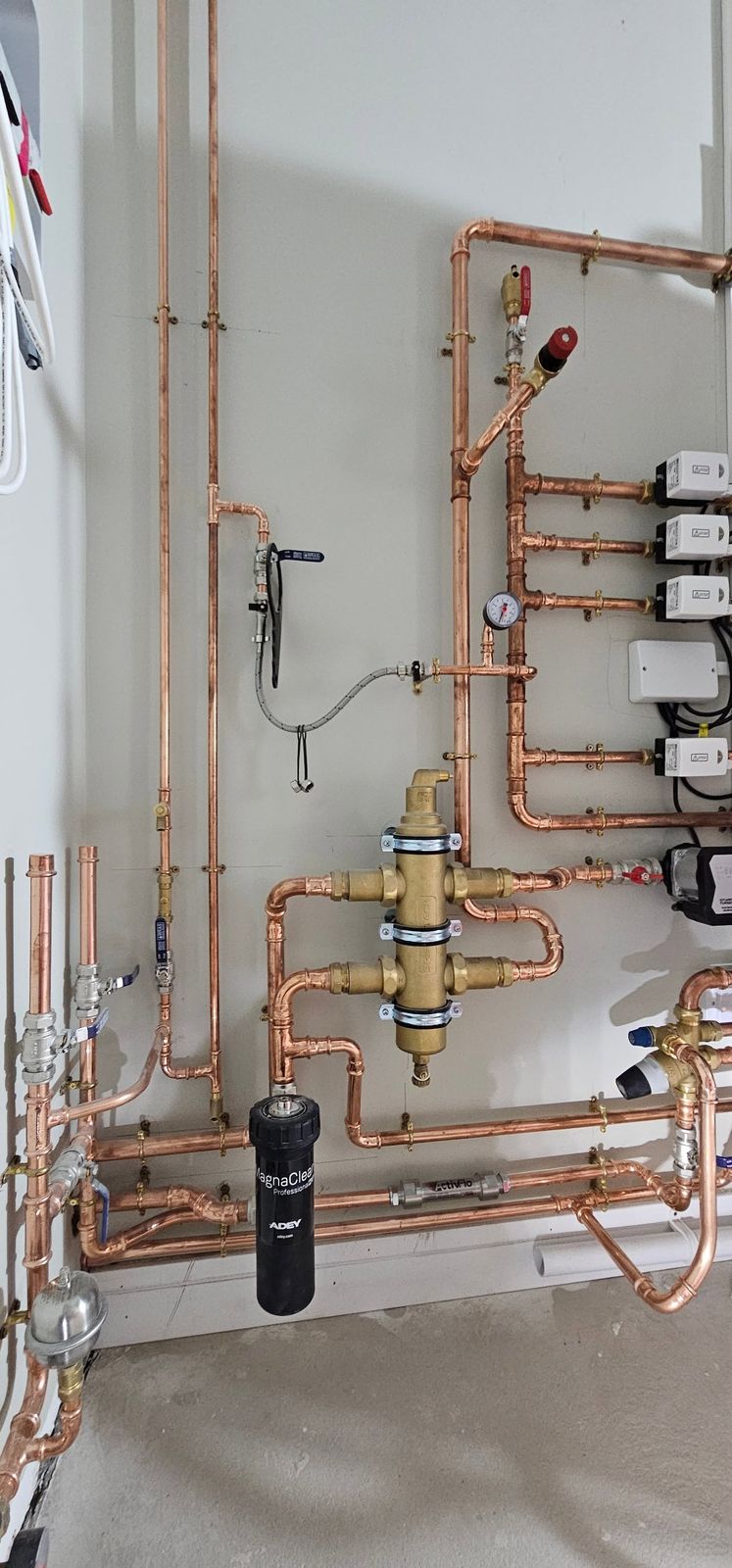 Copper pipework with pumps and valves on a white wall